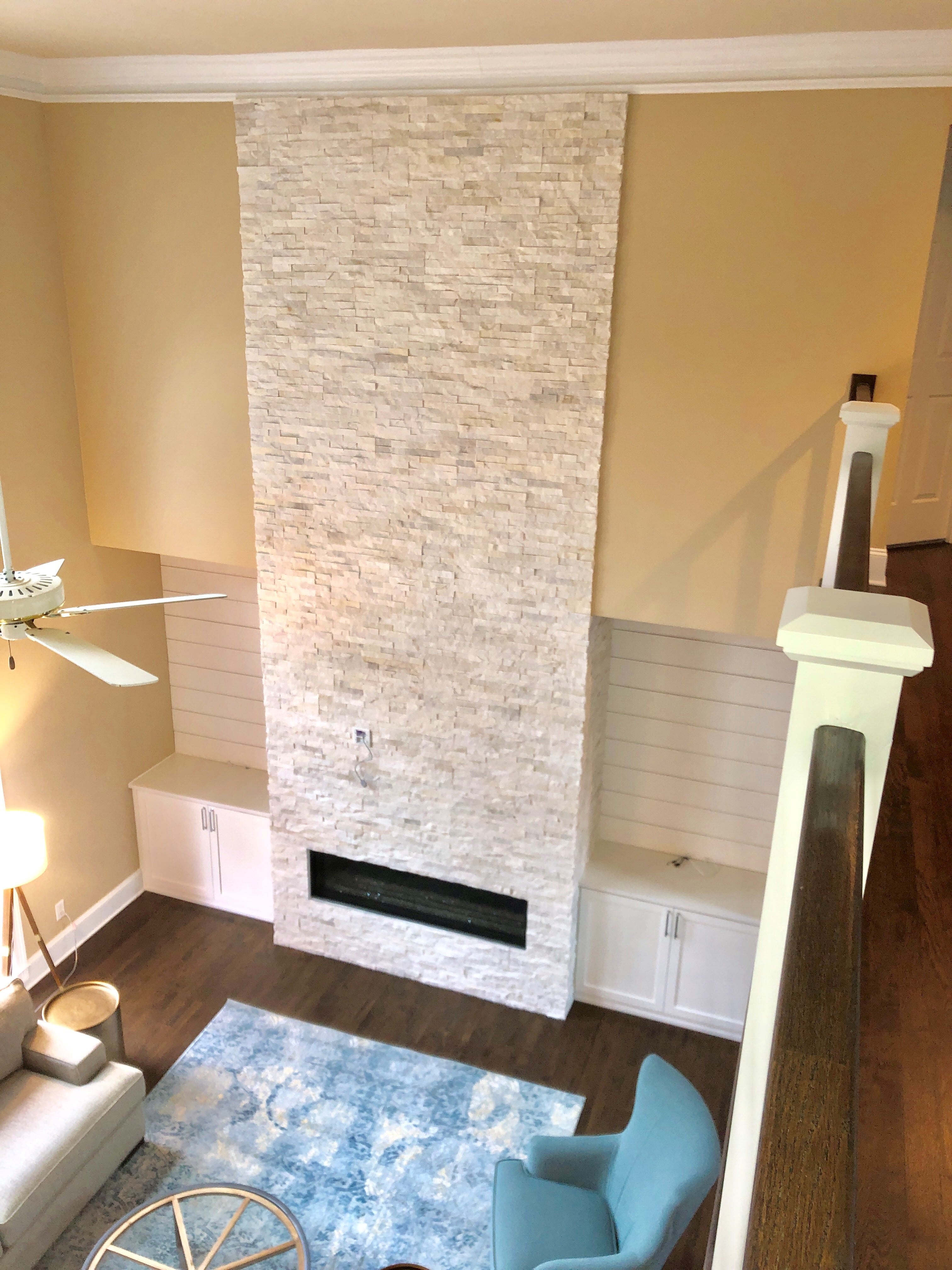 Norstone White Rock Panels used on a two story residential fireplace as seen from an upper stairway looking down
